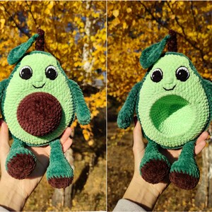 K&ouml;nnte beinhalten: Ein gr&uuml;nes, geh&auml;keltes Avocado-Pl&uuml;schtier mit einem braunen Kern und einem l&auml;chelnden Gesicht. Das Spielzeug hat kleine Beine und ein Blatt oben drauf.