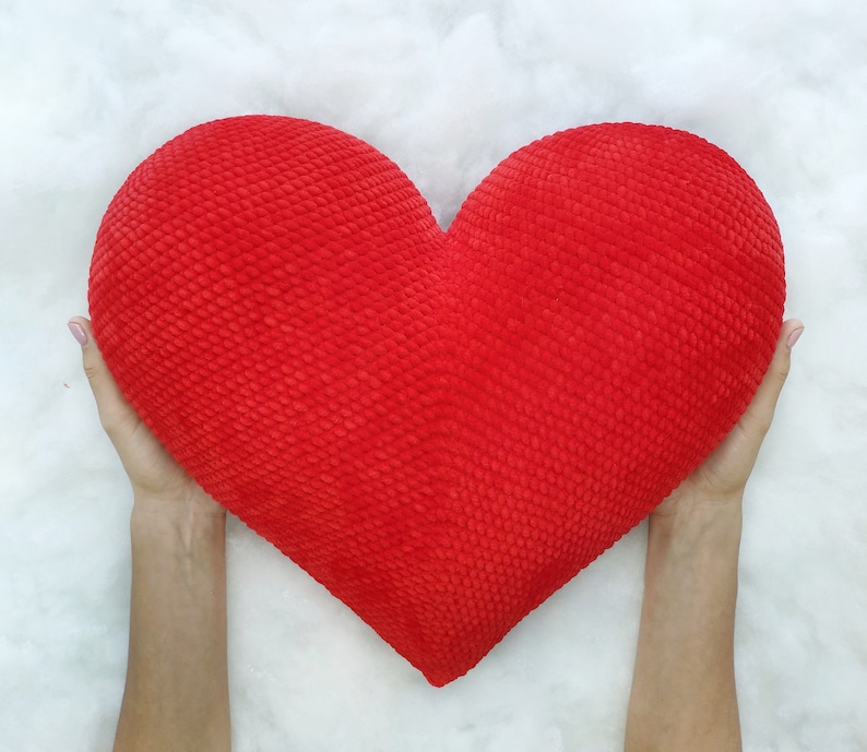 May include: A large red heart-shaped pillow with a textured surface.
