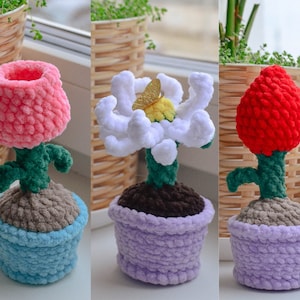 Puede incluir: Tres plantas en maceta de ganchillo con flores de diferentes colores. La primera planta tiene una flor rosa, la segunda planta tiene una flor blanca y la tercera planta tiene una flor roja.