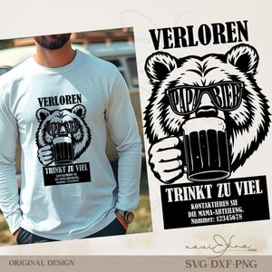May include: A white long-sleeved shirt with a black and white bear graphic. The bear wears sunglasses that say "PAPA BIER" and holds a beer mug. The German text "VERLOREN" and "TRINKT ZU VIEL" are above and below the bear illustration.