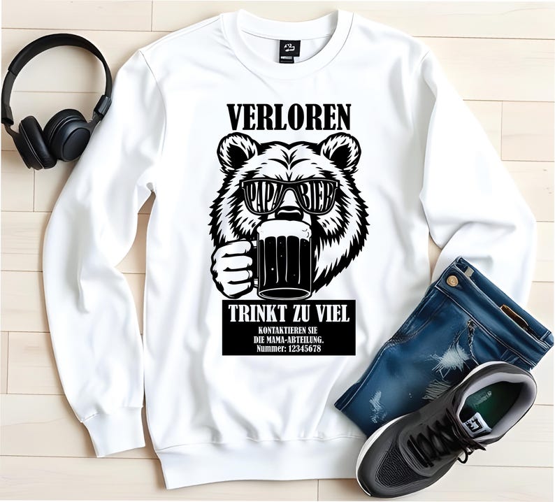 May include: White sweatshirt featuring a black and white bear graphic wearing sunglasses and holding a beer mug. The text on the sweatshirt reads "VERLOREN PAPA BIER TRINKT ZU VIEL".