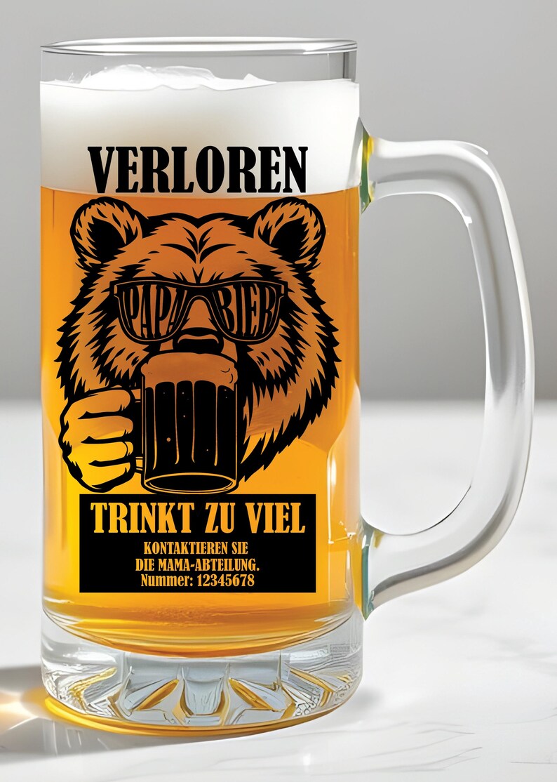 May include: A clear glass beer mug filled with beer and foam. The mug has a black graphic of a bear wearing sunglasses that say "PAPA BIER" and holding a beer mug. Text on the mug reads "VERLOREN" and "TRINKT ZU VIEL".