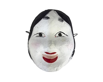 May include: A traditional Japanese Noh theater mask. The mask features a white face with black hair, black eyebrows, and red lips. The eyes are black with a slight upward curve. The mask has a serene expression and is designed to be worn.