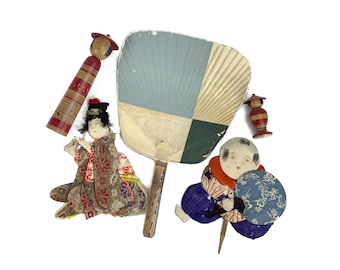 May include: A collection of vintage Japanese dolls and a hand fan. The dolls are made of wood and painted in bright colors. The fan is made of paper and has a blue and green design.