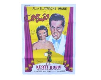 May include: A vintage movie poster for the film "Kesset Hobbi" starring Farid El Atrache and Imane. The poster features a yellow background with a red curtain on either side. The title of the film is written in Arabic script in the center of the poster. The actors' names are listed below the title. The poster also includes the text "Le Roman de Mon Amour" and the names of the supporting actors.