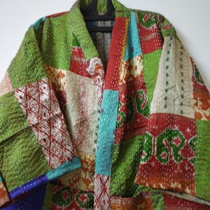 Può includere: Una giacca colorata a patchwork realizzata in tessuto kantha. La giacca presenta un design a patchwork verde, blu, rosso e bianco. La giacca è trapuntata e ha uno stile tradizionale indiano.