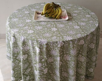 Può includere: Una tovaglia verde con un motivo floreale bianco. Un piatto di banane si trova sulla tovaglia.