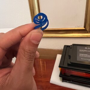 May include: A blue plastic ring with a spiral design.