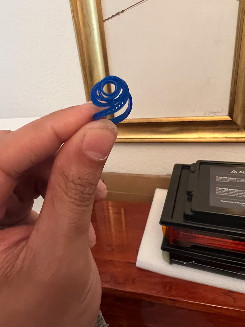 May include: A blue plastic ring with a spiral design.