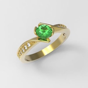 May include: A gold ring with a green gemstone and small diamonds set in the band.