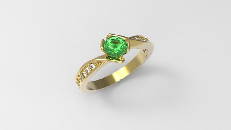 May include: A gold ring with a green gemstone and small diamonds set in the band.