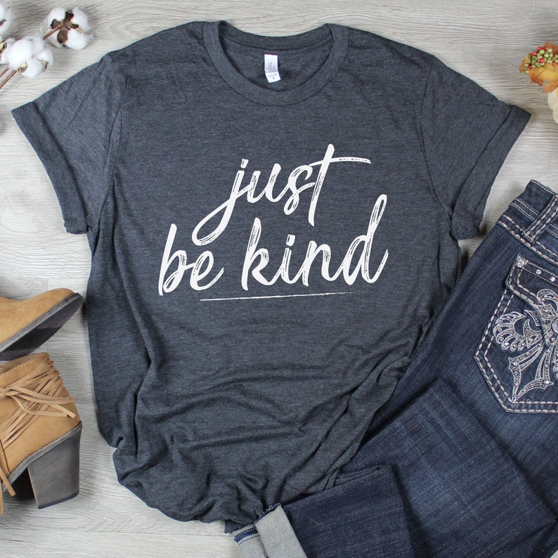 May include: A dark gray t-shirt with the text "just be kind" written in white cursive script.