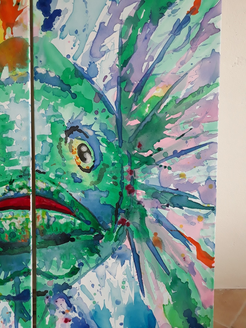 May include: Abstract watercolour painting showing a close-up of a green creature with a large eye and red mouth. The artwork uses a vibrant palette of green, blue, purple, and orange hues, with visible brushstrokes and splatters. The painting is on a white canvas.