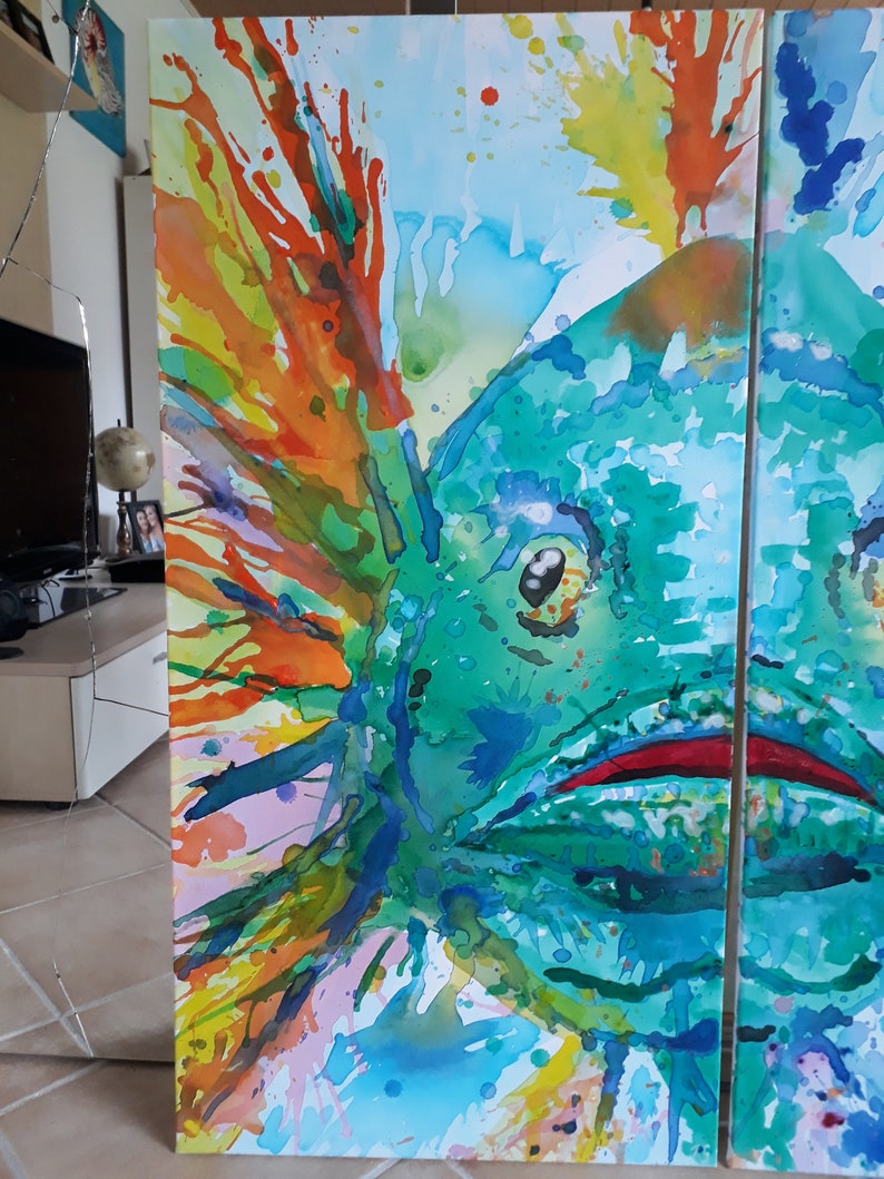 May include: Abstract watercolour painting of a fish in shades of teal, green, orange, and yellow. The artwork is divided into three panels, with the fish's eye and mouth visible. Splashes of colour create a dynamic and vibrant composition.