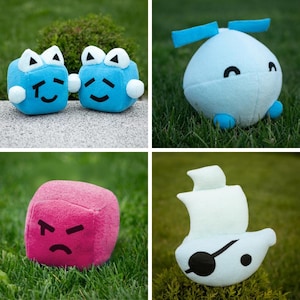 May include: Four plush toys on grass. Two blue cube-shaped toys with white accents and smiling faces. A light blue, round toy with blue propeller-like features. A pink cube with an angry face. A light blue toy boat.