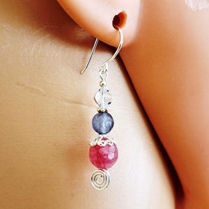 May include: Silver dangle earrings with a pink, blue, and clear gemstone bead design.