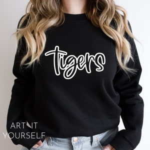 May include: Black sweatshirt with white text that says "Tigers" in a handwritten style.