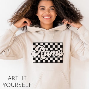 May include: A cream-colored hoodie with a black and white checkered design and the word "Rams" in a retro font.