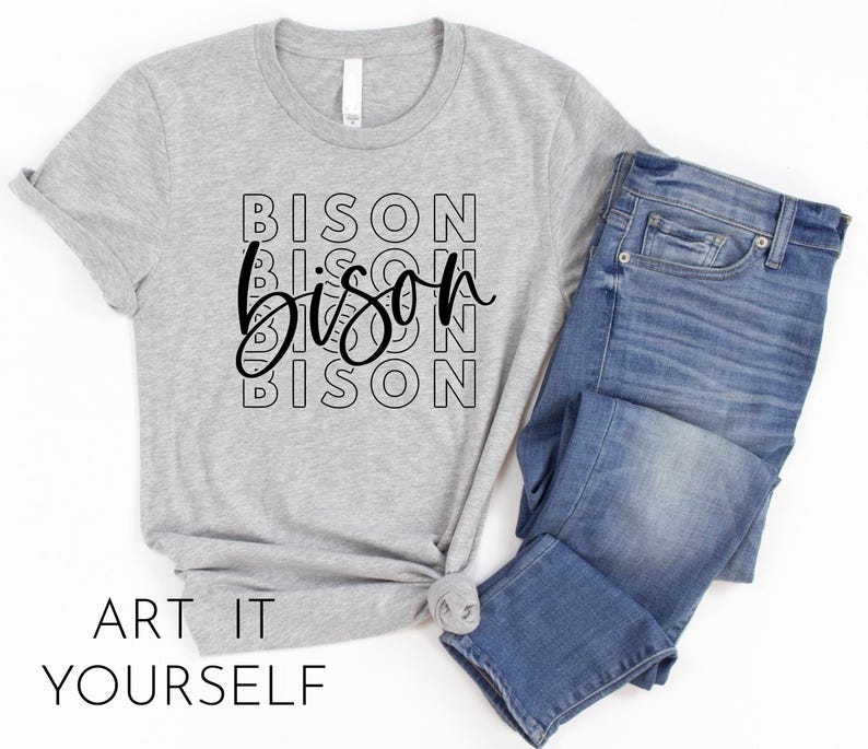 May include: Grey t-shirt with the word "Bison" repeated in black lettering, stacked on top of each other. The word "Bison" is written in a stylised font with a curved "B" and a swirly "S".