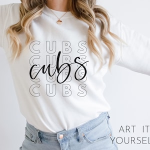 May include: White sweatshirt with the word "CUBS" repeated in a stacked design. The word "cubs" is also written in a cursive font over the stacked text. The phrase "ART IT YOURSELF" is printed in the bottom right corner.