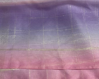 May include: A sheer fabric with a gradient of pink and purple colors. The fabric has a subtle grid pattern with silver threads woven throughout.