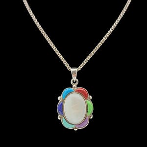 May include: Silver necklace with a pendant featuring a central oval white stone surrounded by colorful petals. The petals are in shades of red, green, blue, purple, and turquoise. The chain is a braided design.
