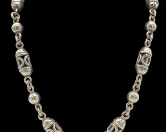 May include: A silver necklace with a chain and oval-shaped beads. Each bead has a decorative design.