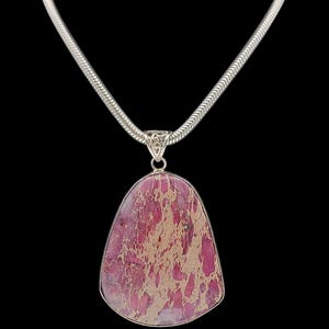 Peut inclure: Un collier en chaîne argent avec un pendentif en pierre marbrée rose et or.
