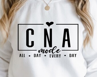 May include: White sweatshirt with black text that reads "CNA mode all day every day" with a small black heart above the text.