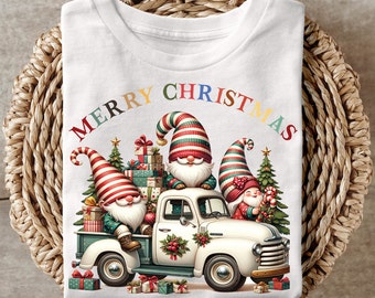 May include: White t-shirt with a colorful "Merry Christmas" text and a vintage truck carrying three gnomes and presents. The gnomes are wearing red and white striped hats and have white beards.