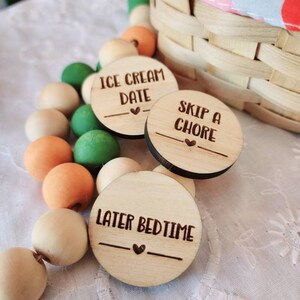May include: Three wooden circles with different phrases written on them. The phrases are "Ice Cream Date", "Skip a Chore", and "Later Bedtime".
