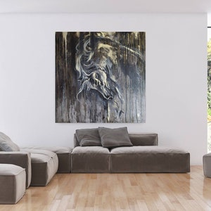 K&ouml;nnte beinhalten: Ein graues Ecksofa mit einem gro&szlig;en abstrakten Gem&auml;lde eines Pferdekopfes in Graut&ouml;nen und Gold, das dar&uuml;ber h&auml;ngt. Das Gem&auml;lde ist auf einer strukturierten Leinwand und hat einen abgenutzten Look. Das Sofa befindet sich in einem modernen Wohnzimmer mit gro&szlig;en Fenstern und einer Topfpflanze.