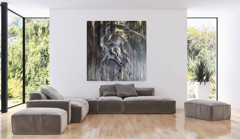 K&ouml;nnte beinhalten: Ein graues Ecksofa mit einem gro&szlig;en abstrakten Gem&auml;lde eines Pferdekopfes in Graut&ouml;nen und Gold, das dar&uuml;ber h&auml;ngt. Das Gem&auml;lde ist auf einer strukturierten Leinwand und hat einen abgenutzten Look. Das Sofa befindet sich in einem modernen Wohnzimmer mit gro&szlig;en Fenstern und einer Topfpflanze.