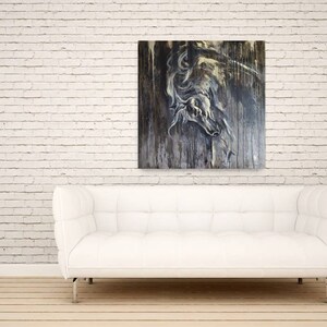 K&ouml;nnte beinhalten: Ein wei&szlig;es Sofa mit einer wei&szlig;en Backsteinwand im Hintergrund. Ein Gem&auml;lde eines wei&szlig;en Pferdekopfes auf einem dunklen Holzgrund h&auml;ngt &uuml;ber dem Sofa. Ein kleiner Holztisch mit einer Topfpflanze steht rechts neben dem Sofa.