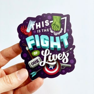 May include: Purple sticker with the text "This is the fight of our lives" in white lettering. The sticker features various superhero-themed illustrations, including a fist, a hammer, an arrow, a shield, and a gun.