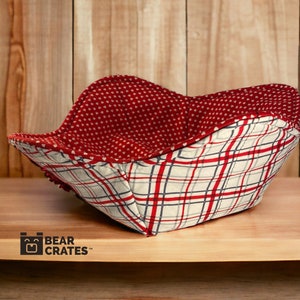 May include: Red and white plaid fabric bowl with a red heart pattern on the inside. The bowl is sitting on a wooden surface. "Bear Crates" is printed on the surface.
