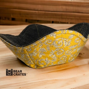 May include: A yellow and gray fabric bowl with a floral pattern. The bowl is made by Bear Crates.