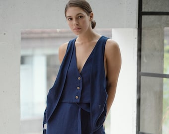 May include: A navy blue linen jumpsuit with a vest top and wide-leg pants. The vest has a V-neck and four buttons down the front.
