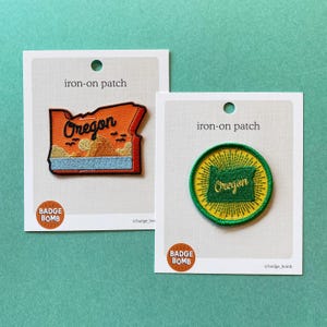 Puede incluir: Un letrero de madera hecho a mano con la palabra "Welcome" en una fuente caprichosa. El letrero está pintado de blanco con un acabado envejecido y presenta un diseño floral en tonos rosas y verdes. Mide aproximadamente 30 cm de ancho.