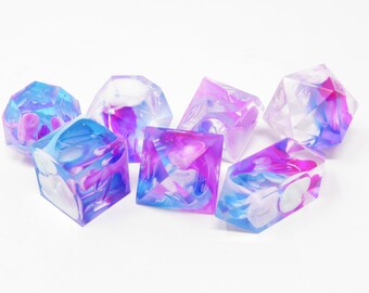 May include: Set of six iridescent dice with a swirl pattern in shades of pink, blue, and white.