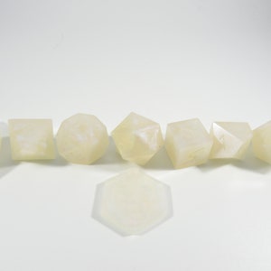 May include: A set of eight white dice with a marbled effect. The dice are in various shapes, including a d4, d6, d8, d10, d12, and d20.