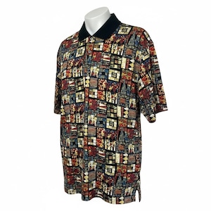May include: A short-sleeve polo shirt featuring a solid black collar and a button-up placket. The fabric displays a multi-colored geometric pattern composed of squares and rectangles in shades of red, blue, yellow, and black, creating a grid-like design.