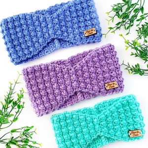 May include: Three crocheted headbands in blue, purple, and teal colors. Each headband has a wooden tag attached that says "Above the Clouds".