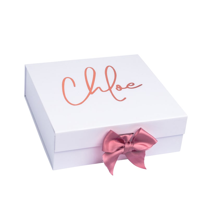 May include: White gift box with a pink satin bow and the name "Chloe" written in rose gold lettering.
