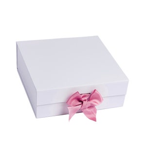 May include: A white gift box with a pink satin ribbon bow.