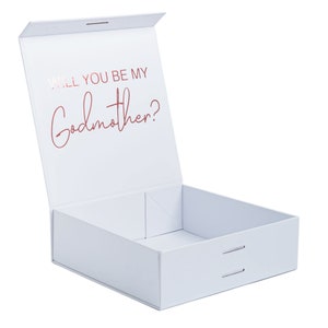May include: White gift box with a lid that opens to reveal the words "Will you be my Godmother?" in rose gold lettering.