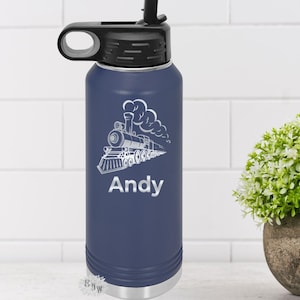May include: A navy blue stainless steel water bottle with a black lid and a white design of a steam engine train with the name "Andy" engraved on the side.