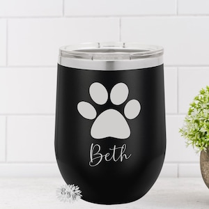 May include: Black stainless steel tumbler with a white paw print and the name "Beth" printed on the side.