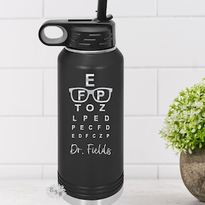 May include: Black stainless steel water bottle with a white eye chart and the text "E FP TOZ L PED PECFD EDFCZP Dr. Fields".
