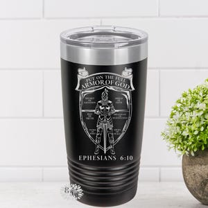 May include: A black stainless steel tumbler with a white graphic of a knight in armor. The graphic includes the text "Put on the full armor of God" and "Ephesians 6:10".